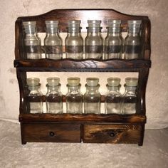 an old wooden shelf filled with glass bottles