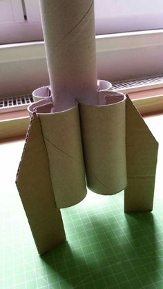 two rolls of toilet paper are stacked on top of each other in front of a window