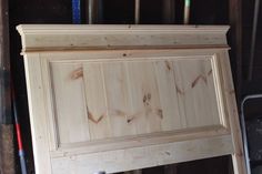 an unfinished wooden cabinet is shown in the process of being built with woodworking tools