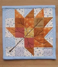 an orange and yellow quilted star with leaves on it