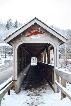 a covered bridge with snow falling on the ground