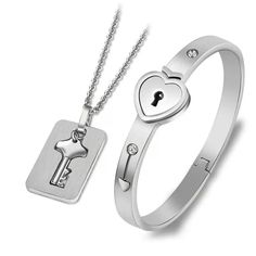 two pieces of jewelry with a heart and key on it, one is in the shape of a lock