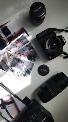 the camera is sitting next to some pictures and other items on top of a table