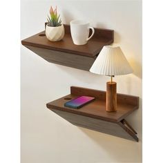 two wooden shelfs with one holding a phone and the other holding a lamp