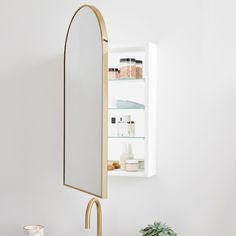 a bathroom sink with a mirror above it and a shelf in the wall behind it