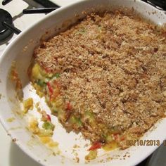 a casserole dish with crumbs and vegetables in it on the stove