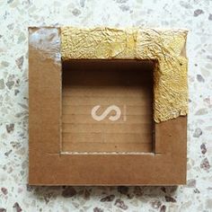 an open cardboard box sitting on top of a table next to a white and brown wall