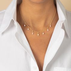 The Adina Eden CZ X Pearl Shaker Necklace is a beautifully delicate piece, crafted from brass and plated in radiant 14K gold. This necklace features an enchanting mix of clear CZ stones and faux pearls that "shake" with movement, adding dynamic sparkle and elegance to any look. Measuring 16" with a 2" extender, it allows for a versatile fit, perfect for layering or wearing alone as a refined statement. This necklace combines timeless charm with a modern twist, making it a standout addition to an Shaker Necklace, Pearl And Gold Necklace, Special Occasion Jewelry, Cz Stone, Pearl White, Faux Pearl, Eden, Pearl Necklace, Layering