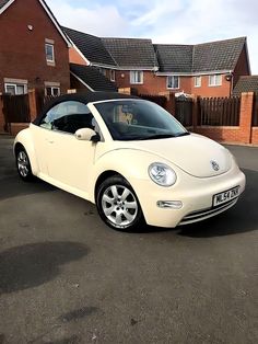 a white convertible car parked in front of a house