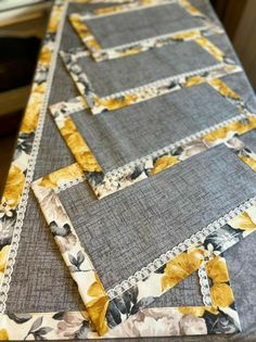 the table is covered with yellow and gray fabric, along with matching placemats