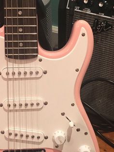 a pink electric guitar sitting on top of a table