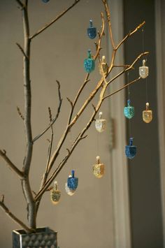 a small tree with blue and yellow ornaments hanging from it's branches in front of a window