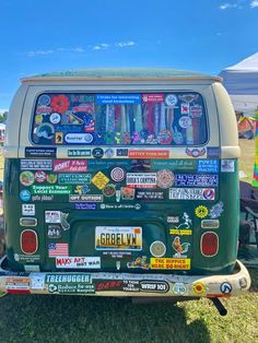 the back end of an old green van with stickers and decals on it