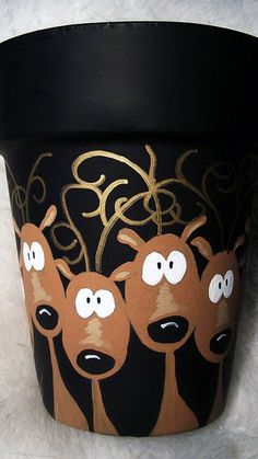 a pot with three reindeer faces painted on it