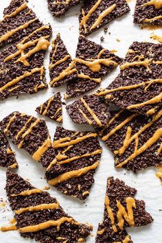 chocolate cookies with caramel drizzled on top, sitting on a sheet of parchment paper