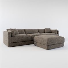 a large sectional sofa with footstool in front of a white wall and floor