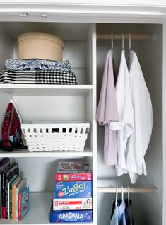 an organized closet with clothes, books and other items on shelves next to a basket