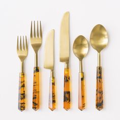 an assortment of gold colored utensils and spoons