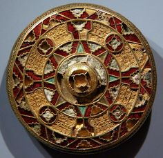 a gold and red circular object on a wall