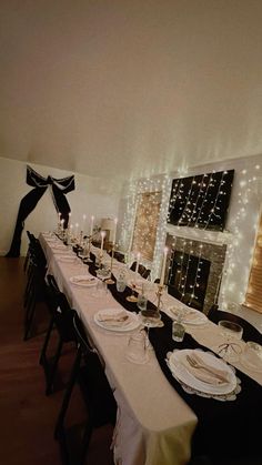 a long table is set with white plates and place settings for an elegant dinner party