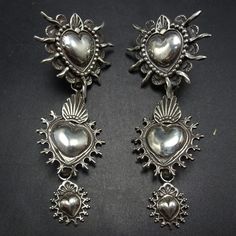 GREGORY SEGURA SOUTHWEST SANTA FE ARTISAN STERLING SILVER  EARRINGS DESCRIPTION:  A triple tier dangle of graduating solid sterling silver hearts... Santa Rosa sacred Heart, the Mesilla Burning heart and the Taos Sacred Heart. These magnificent earrings by celebrated Santa Fe silversmith Gregory Segura will be a cherished addition to your collection of quality Southwestern and Native American jewelry. MEASUREMENTS: Earrings measure 2 3/4"  x  1 1/4" WEIGHT:  25.9 grams SIGNED:  Gregory Segura  S Charm Ideas, Jewelry Measurements, Burning Heart, Sterling Silver Heart Earrings, Cowgirl Jewelry, Silver Heart Earrings, Dope Jewelry, Silver Dangle Earrings, Taos