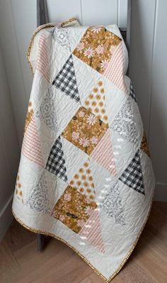 a quilted blanket sitting on top of a chair next to a white wooden door