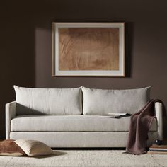 a living room with a couch, rug and painting hanging on the wall above it