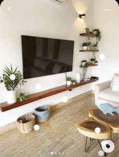 a flat screen tv mounted on the wall in a living room next to two stools