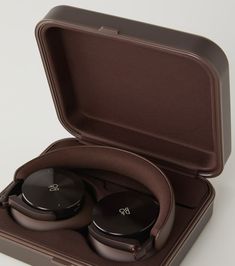 an open case with two black headphones in it