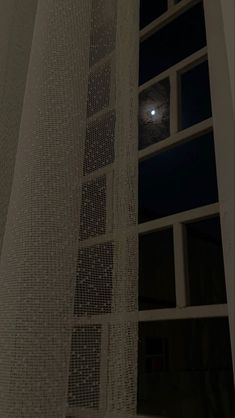 the moon is seen through the window at night