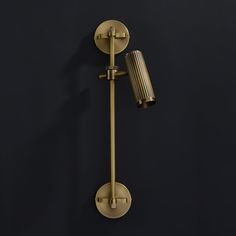 an old fashioned brass wall light on a dark background with a dim lighting bulb in the corner