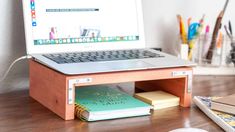 an open laptop computer sitting on top of a wooden desk