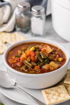 a bowl of vegetable soup with crackers on the side