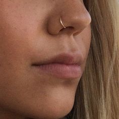 a close up view of a woman's nose and nose piercings