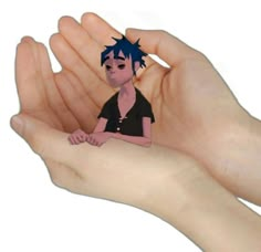 a person's hand holding a small cartoon character