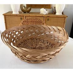 a wicker basket sitting on top of a table next to a dresser and mirror