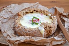 a bread bowl with cheese and vegetables in it