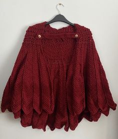 a red sweater hanging on a white wall