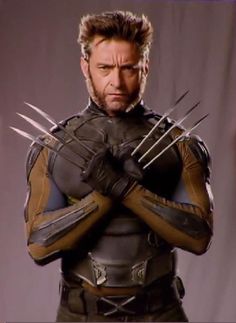 a man with claws on his chest and hands in front of him, wearing a wolverine costume