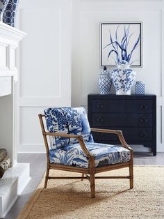 a blue and white chair sitting in front of a fireplace