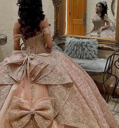 a woman in a ball gown looking at herself in the mirror