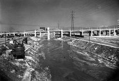 an old black and white photo of a train going over a bridge in the snow