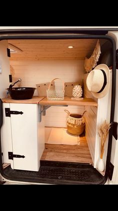 the inside of a van with its door open and shelves full of items in it