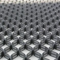 rows of black plastic baskets stacked on top of each other in the middle of a room