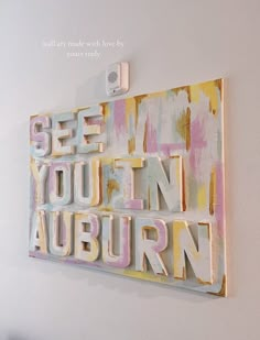 an art piece with the words see you in auburn on it hanging on a wall