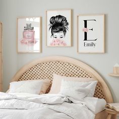 a bed with white sheets, pillows and pictures on the wall