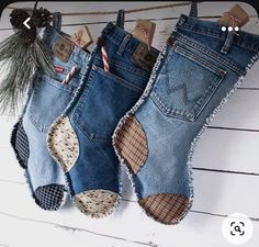 two pairs of jeans hanging from a rope with pine cones on it and the other pair is