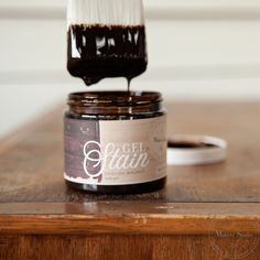 a close up of a paint brush on top of a jar of brown gelatin