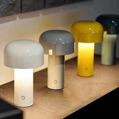 three different colored lamps sitting on top of a counter next to each other in front of a mirror