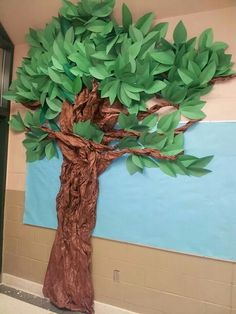 a tree made out of paper sitting on top of a wall